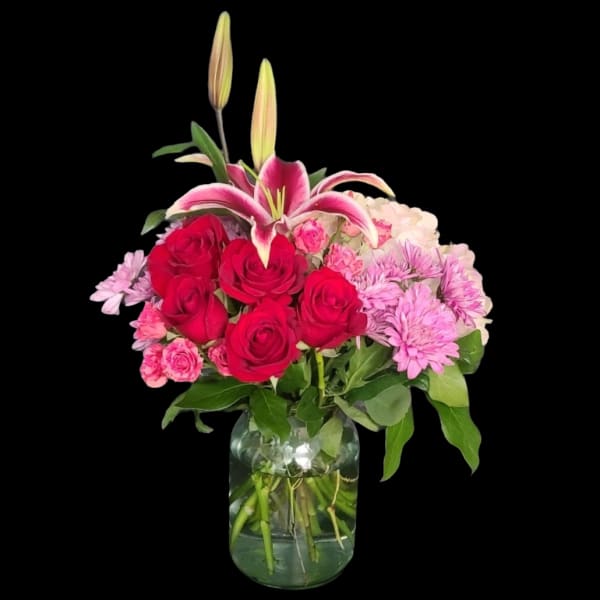 Bouquet of red roses and pink lilies in a glass vase