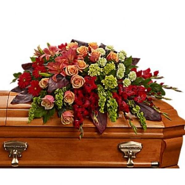 Casket spray with red and peach flowers