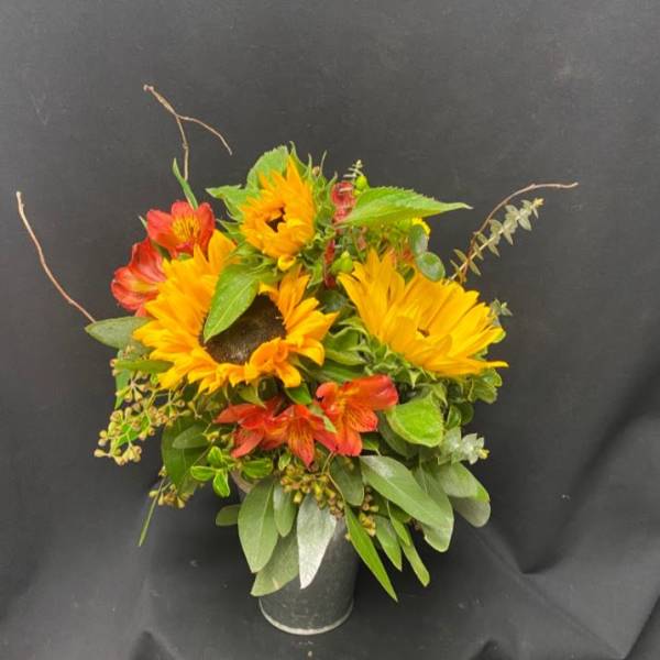 Sunflower and red alstroemeria arrangement in a dark vase