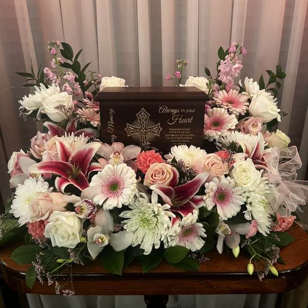 Sympathy floral arrangement around a memorial urn with pink and white flowers