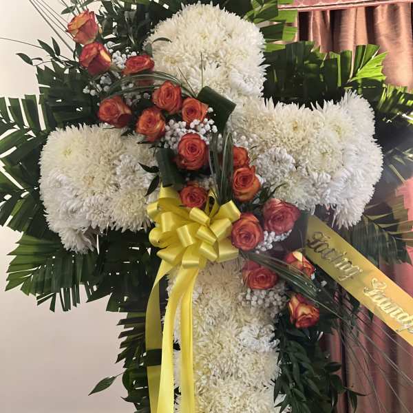 Large floral cross with white chrysanthemums and orange roses