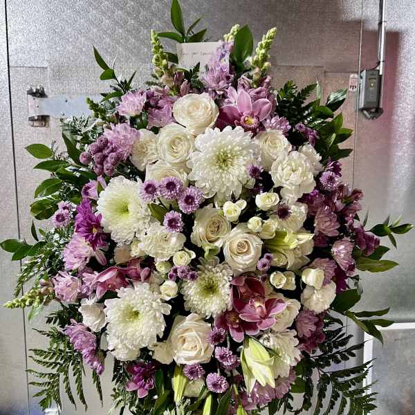 Large standing floral spray with white and pink blooms on an easel