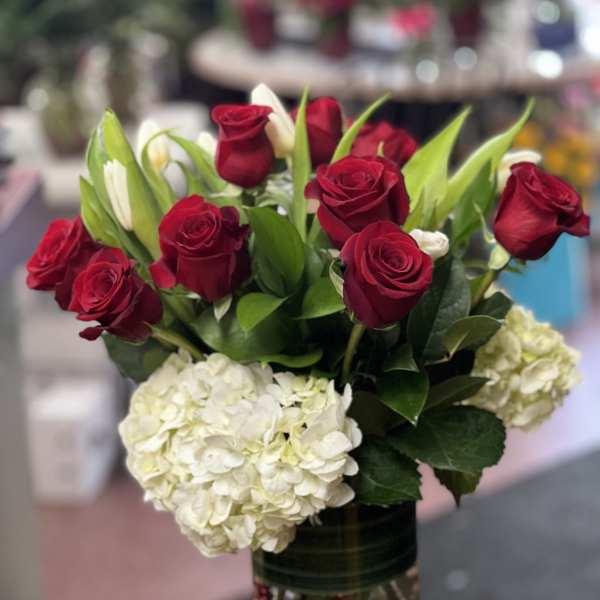 Red roses and white hydrangeas in a glass vase