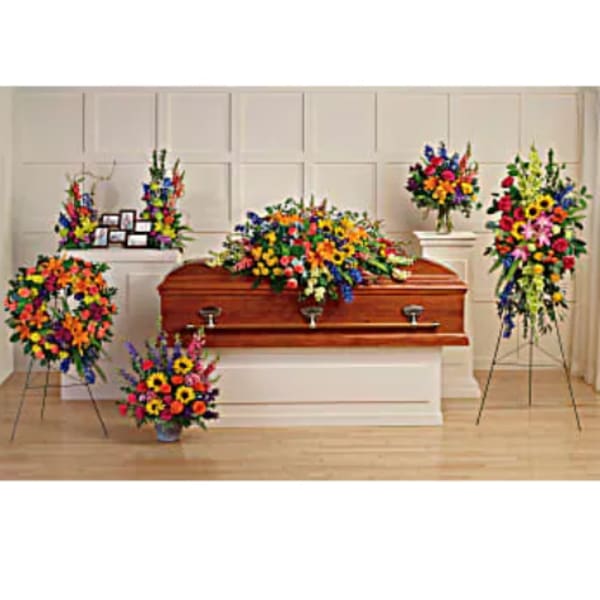Colorful funeral casket spray with matching standing floral arrangements