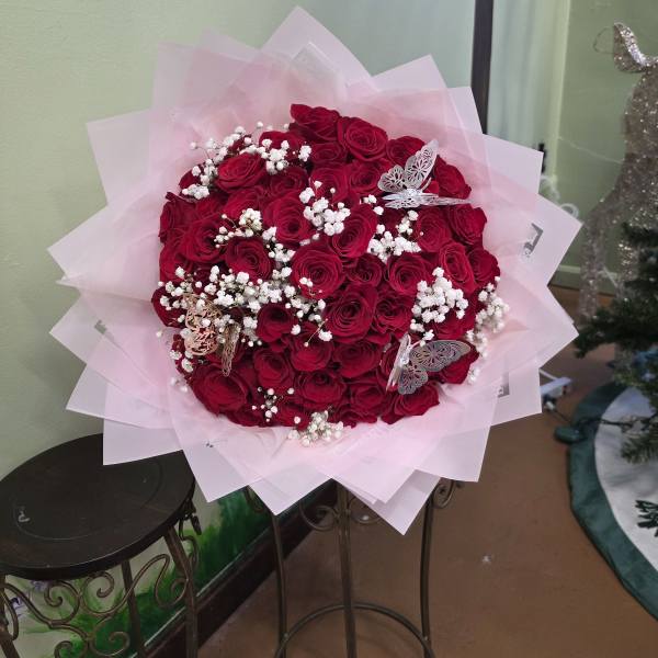Bouquet of red roses with white baby's breath in pink wrap