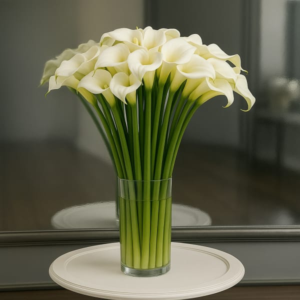 White calla lilies arranged in a clear glass vase