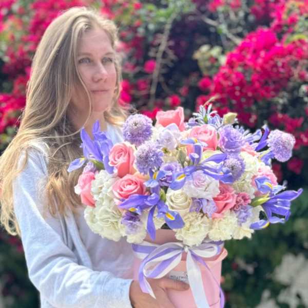 Woman holding a pastel bouquet in a pink hatbox