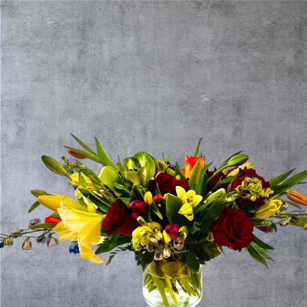 Mixed bouquet of red roses and yellow lilies in a glass vase