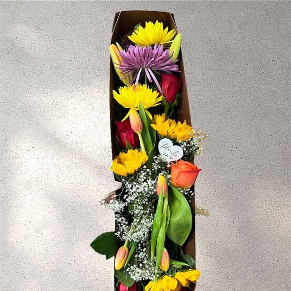 Long box arrangement with roses, tulips, and daisy-like blooms