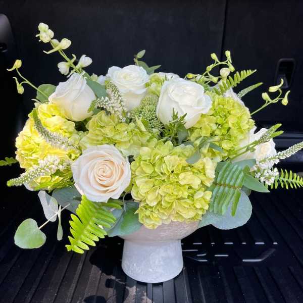 White roses and green hydrangeas in a white vase