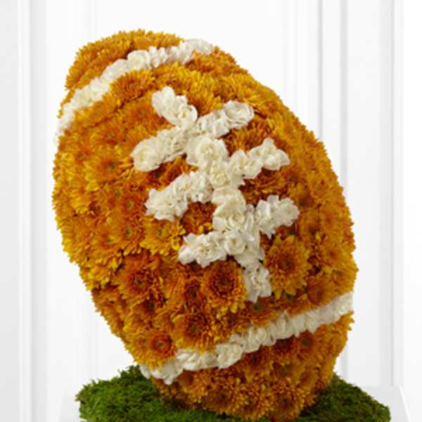 Orange and white chrysanthemum floral sculpture on a green base