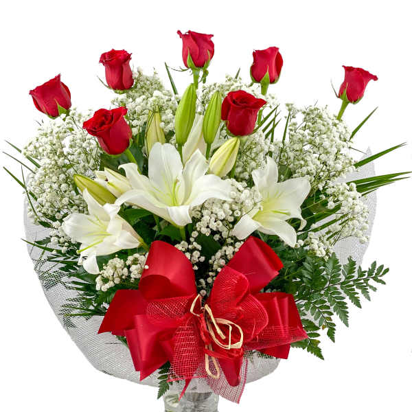 Bouquet of red roses and white lilies in a glass vase with a red bow