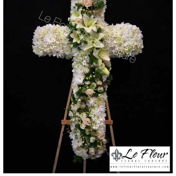 White floral cross arrangement on an easel