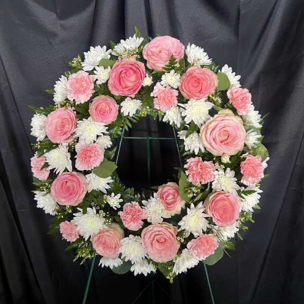 Pink and white floral wreath on a stand