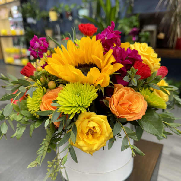 Bright mixed bouquet with sunflowers, roses, and chrysanthemums in a white box