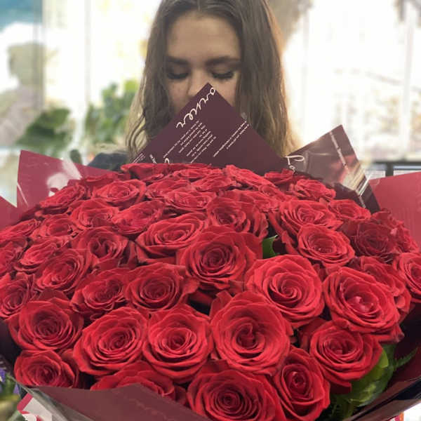 Large bouquet of red roses wrapped in burgundy and pink paper