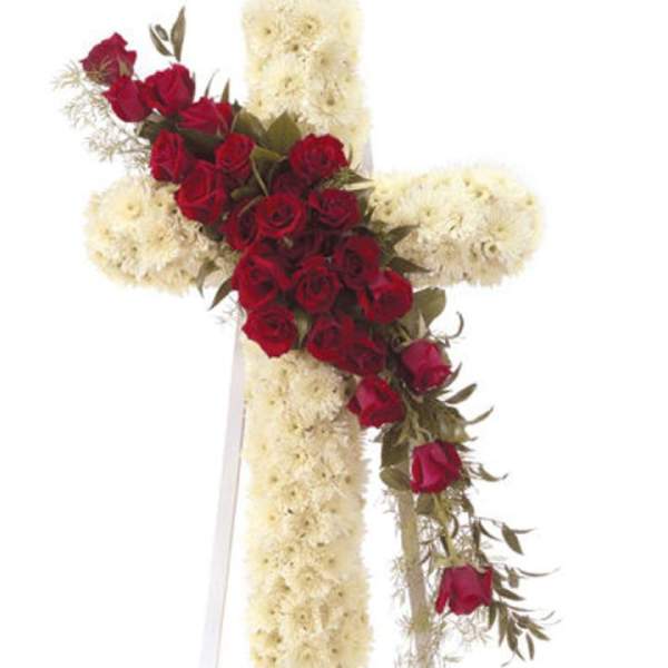 Red roses arranged on a white floral cross