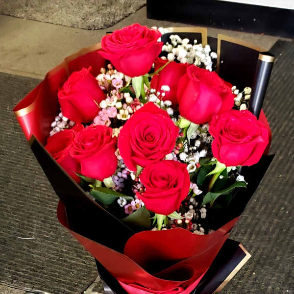 Bouquet of red roses with baby's breath wrapped in red and black paper