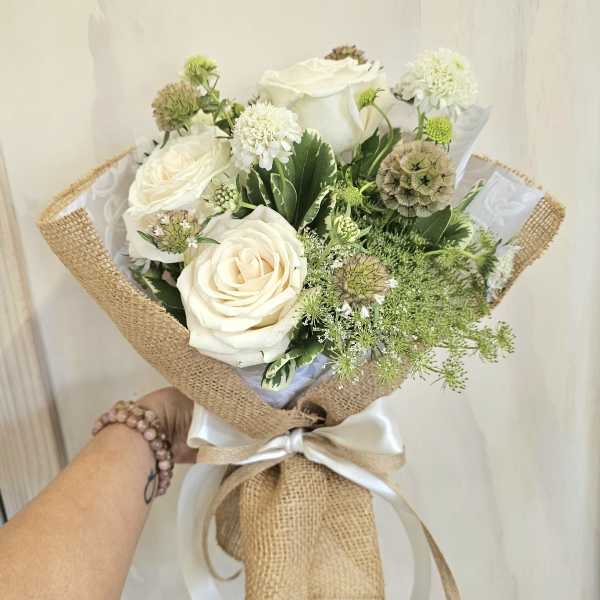 White rose bouquet wrapped in burlap with a satin ribbon