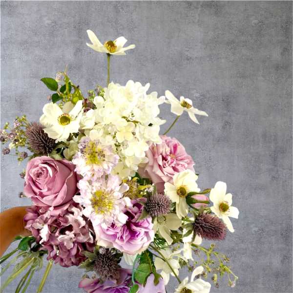 Bouquet of pink roses, white flowers, and purple blooms