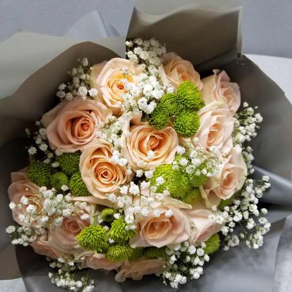 Bouquet of peach roses with white baby's breath and green button mums
