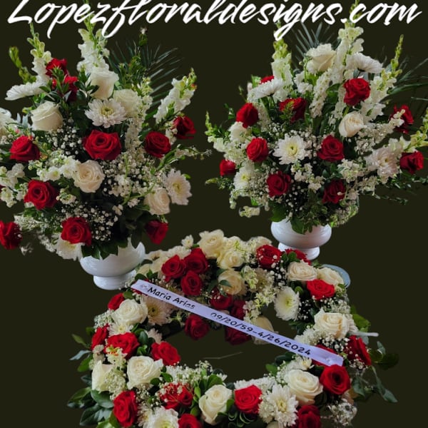 Red and white rose arrangements with white daisies in pedestal vases and a wreath