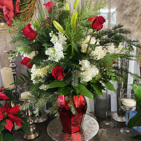 Red roses and white lilies arranged in a red vase
