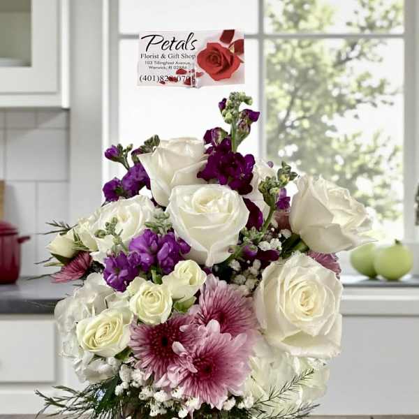 White and purple rose bouquet in a glass vase