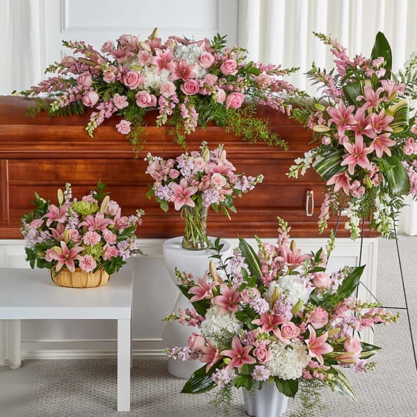 Pink and white funeral flowers arranged around a casket