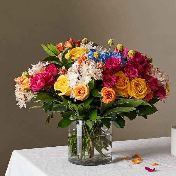 Mixed bouquet of roses and small white flowers in a glass vase