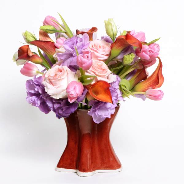 Bouquet of pink, purple, and orange flowers in a red vase