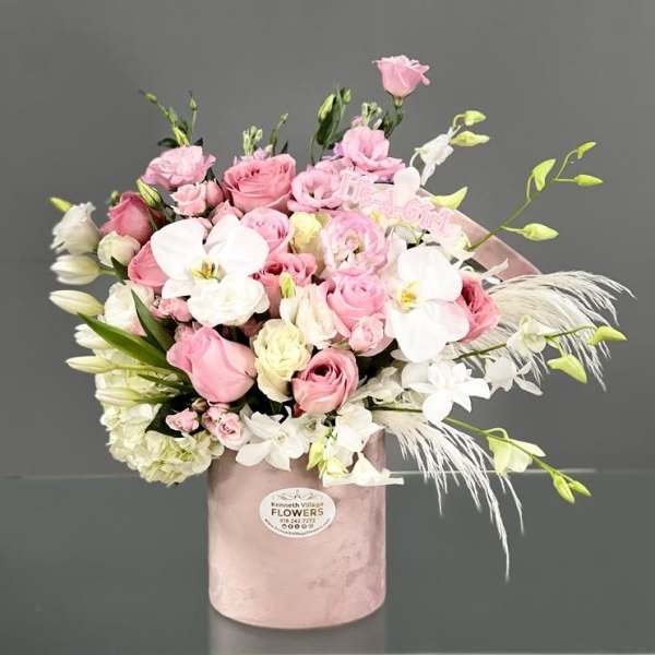 Pink and white bouquet in a blush hatbox with orchids and roses