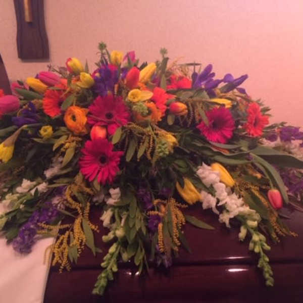 Colorful floral casket spray with gerbera daisies and tulips