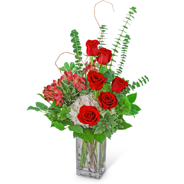 Red roses and pink flowers in a clear glass vase