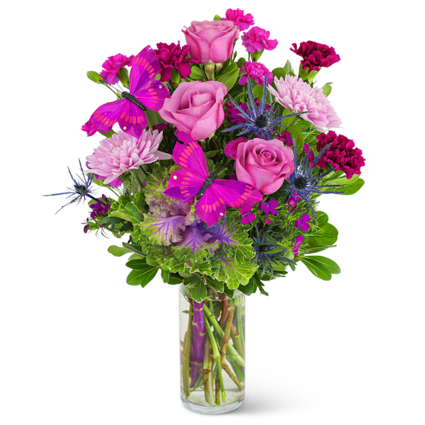 Pink roses and magenta flowers in a clear glass vase with purple butterflies