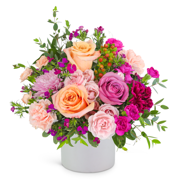 Mixed pink and peach flower arrangement in a white vase