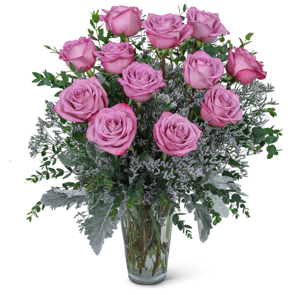 Pink roses arranged in a clear glass vase with silver foliage