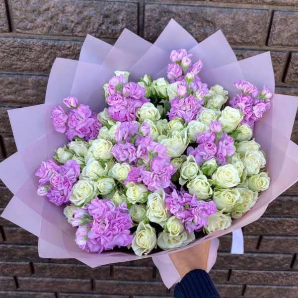 Bouquet of lavender and white roses wrapped in pale pink paper