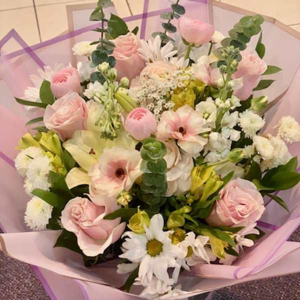 Pink and white mixed bouquet with daisies in pastel wrapping