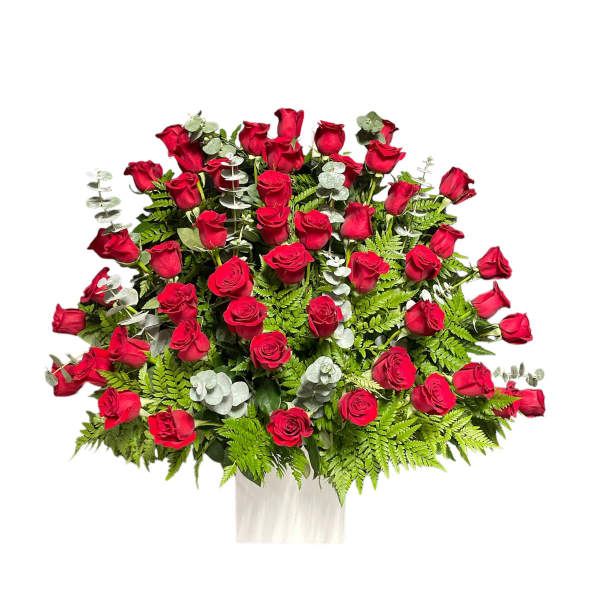 Large bouquet of red roses with fern foliage in a white wrap