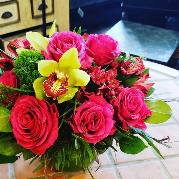 Bouquet of pink roses and yellow orchids with greenery