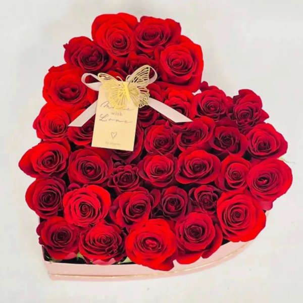 Heart-shaped bouquet of red roses with a ribbon and tag
