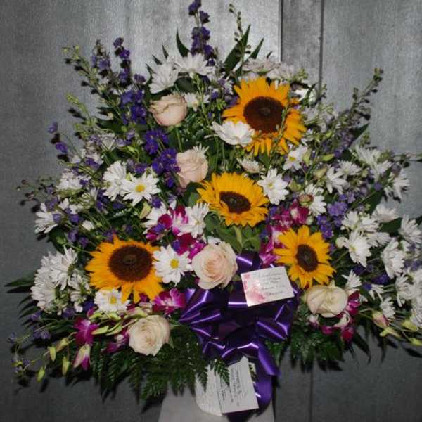 Large mixed flower spray with sunflowers, white daisies, and purple blooms