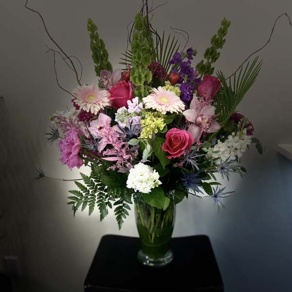 Mixed bouquet in a glass vase with pink, purple, and white flowers