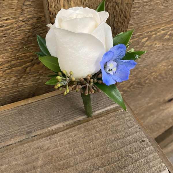 White rose boutonniere with a blue accent flower