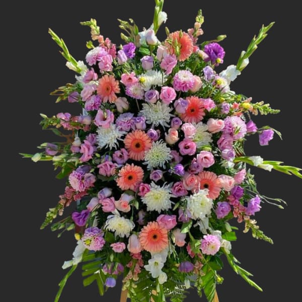 Large standing spray of pink, purple, and white flowers on an easel