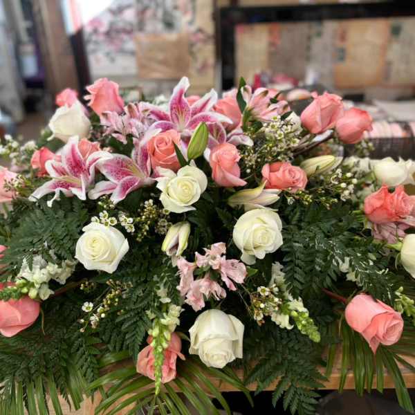 Pink and white roses with lilies in a low floral arrangement