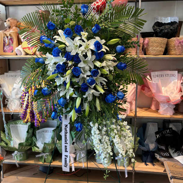 Large standing floral spray with blue roses and white lilies