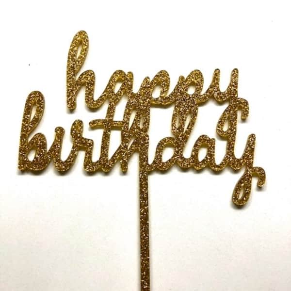 Gold glitter "happy birthday" cake topper on a white background