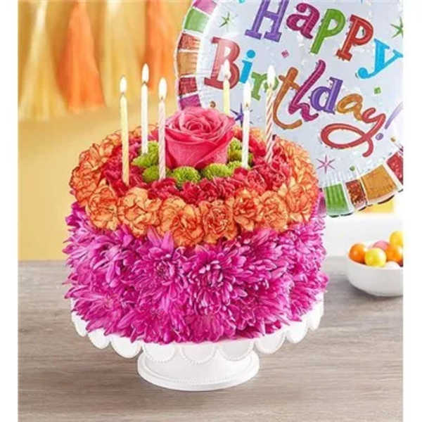 Pink and orange flower cake with candles and a birthday balloon